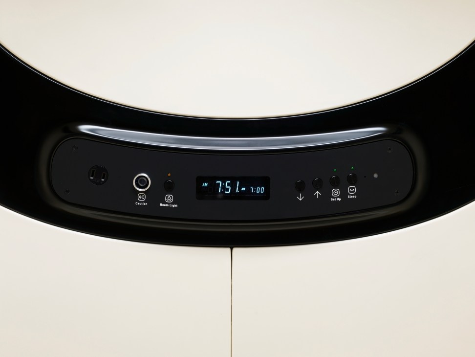 Control panel of a 9 Hours capsule hotel pod showing digital display, buttons and functions in minimalist design.