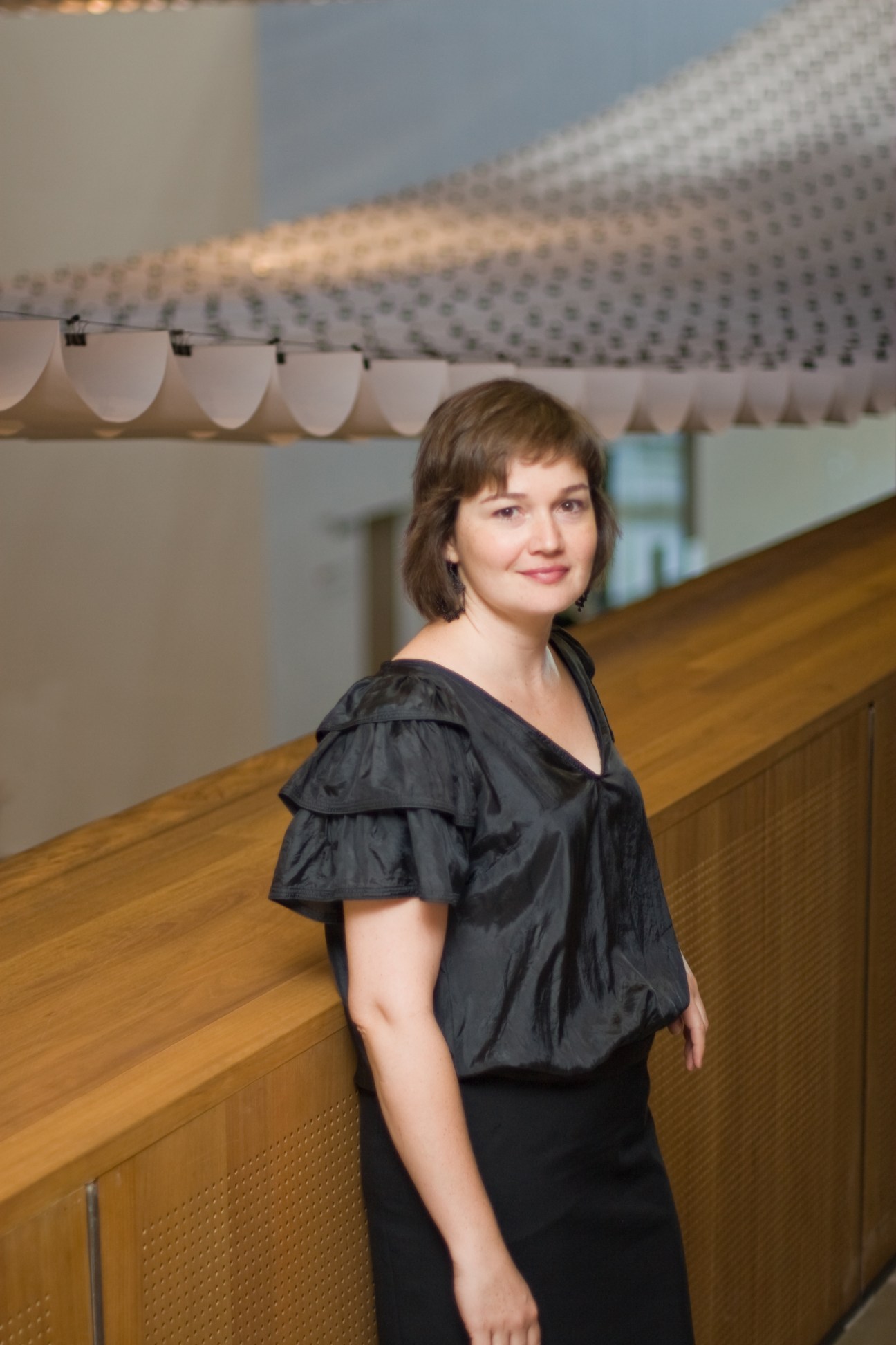 Dr Miranda Wallace, curator at the Gallery of Modern Art, standing in a modern interior space with architectural details.