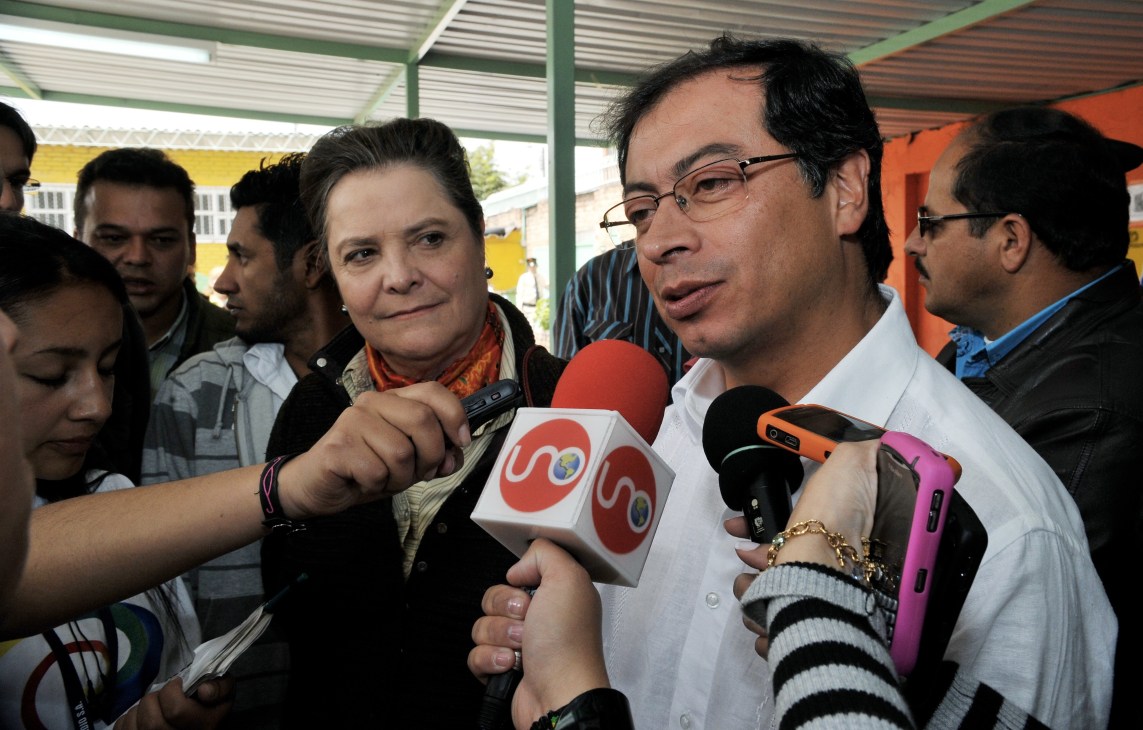 Colombian politician Gustavo Petro speaks to press with microphones during an election campaign event.