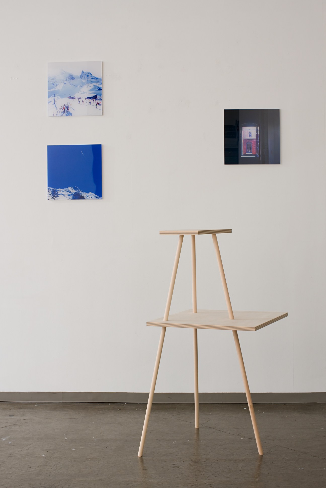 Hiroyuki Tanaka's angular birch and steel furniture piece with two sloping surfaces stacked on tripod legs, displayed in a gallery setting.