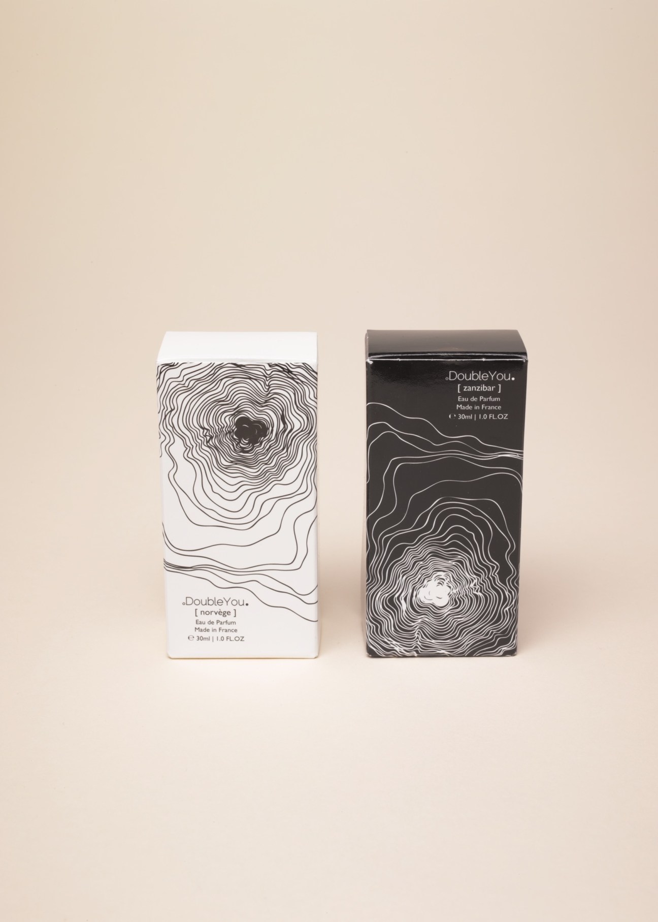 Two DoubleYou perfume boxes with minimalist line-art designs in white and black against a beige background.