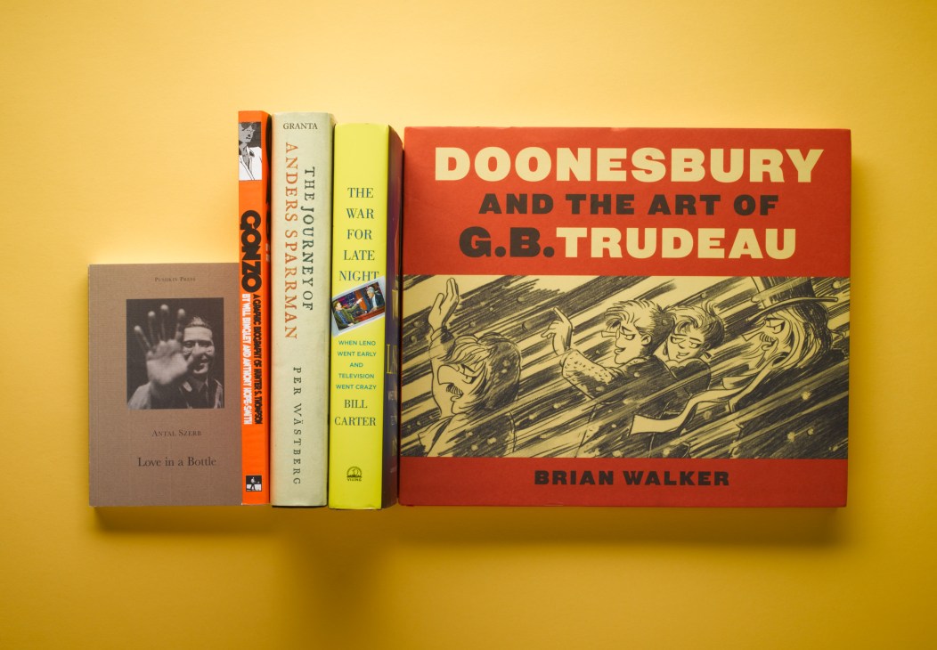 Five books arranged on a yellow background including Love in a Bottle, Gonzo, The War for Late Night, and Doonesbury and the Art of G.B. Trudeau.
