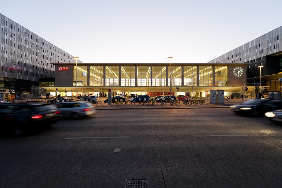 Modern ÖBB railway station facade with illuminated glass windows and contemporary architecture at dusk.