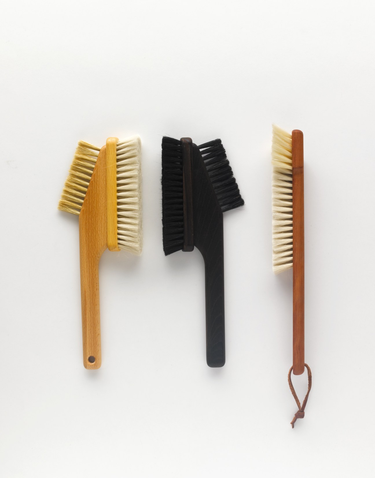 Three handmade brushes with wooden handles and natural bristles by Redecker, displayed against a white background.