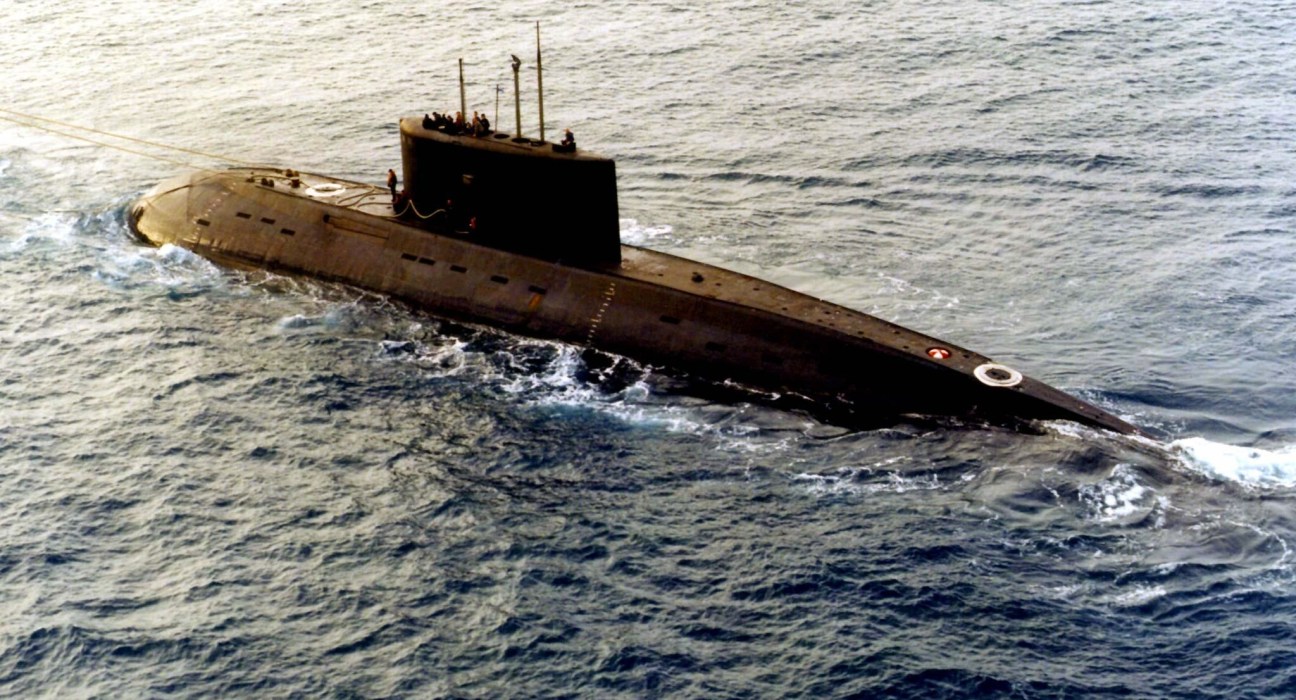 Russian Kilo-class submarine partially submerged in shallow coastal waters.