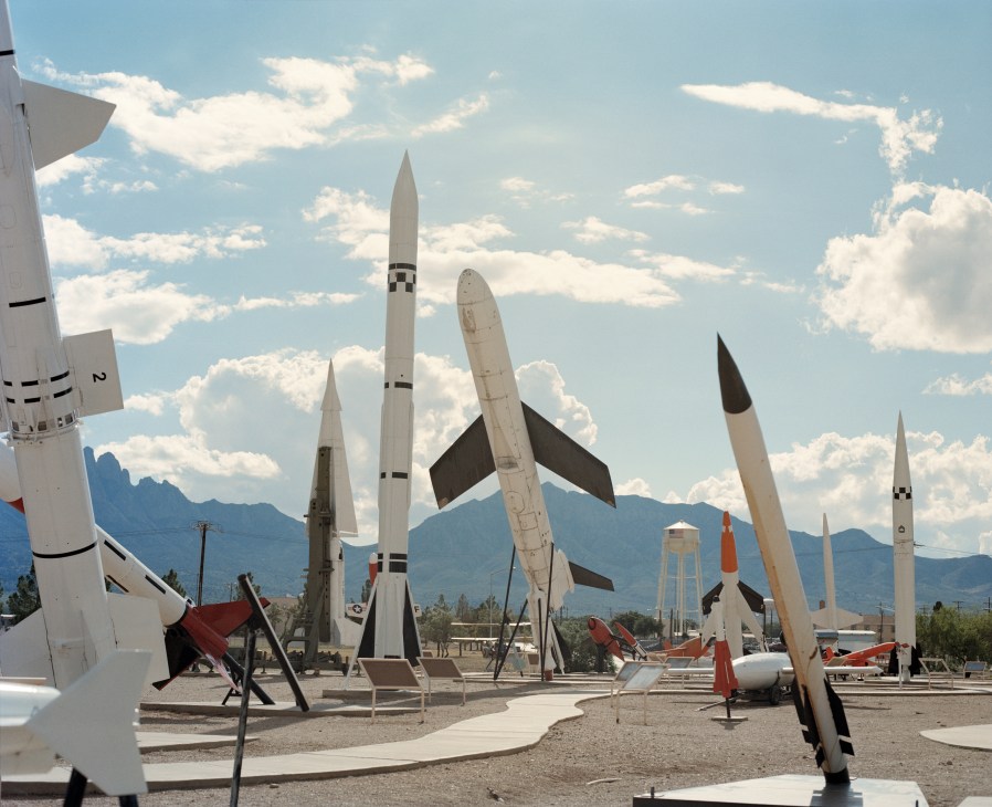 White Sands Missile Range in New Mexico with decommissioned rockets and missiles on display against desert mountains.