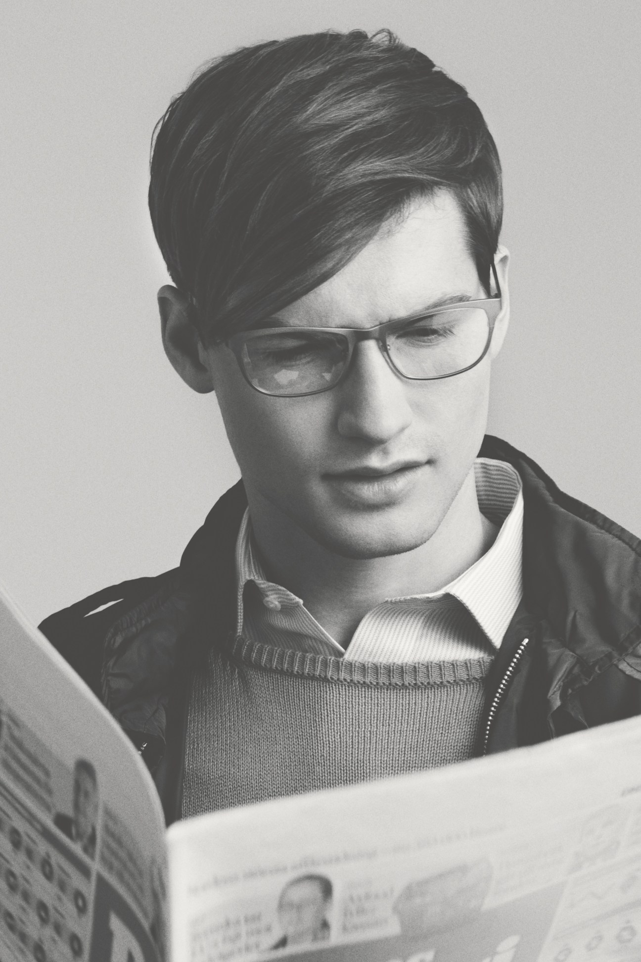 Man wearing Freudenhaus Doc glasses and E. Tautz jumper reading a newspaper.
