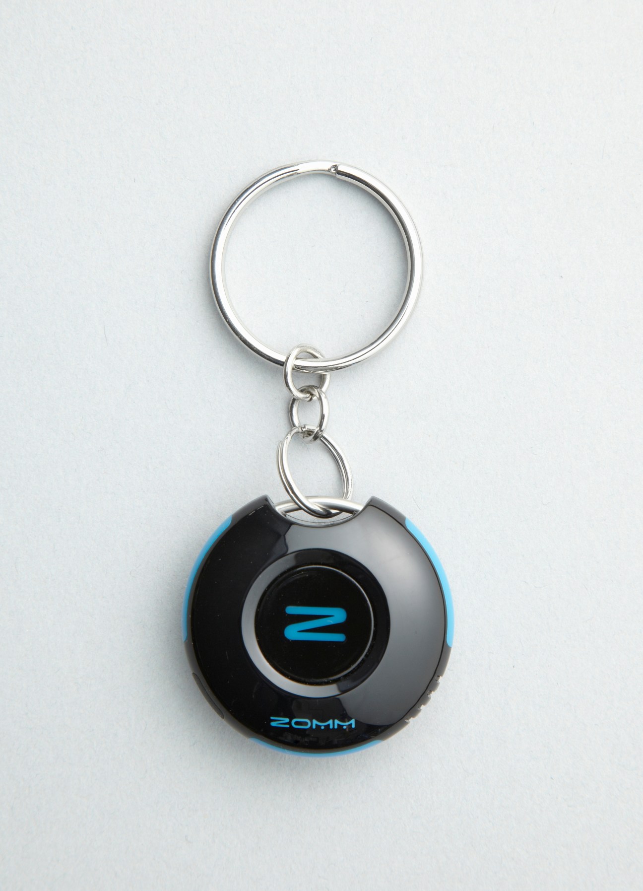 Zomm Bluetooth device keychain with black casing, blue accents and silver keyring attachment.