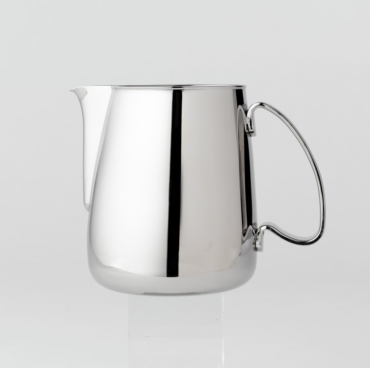 Ilsa stainless steel milk jug with handle against gray background.