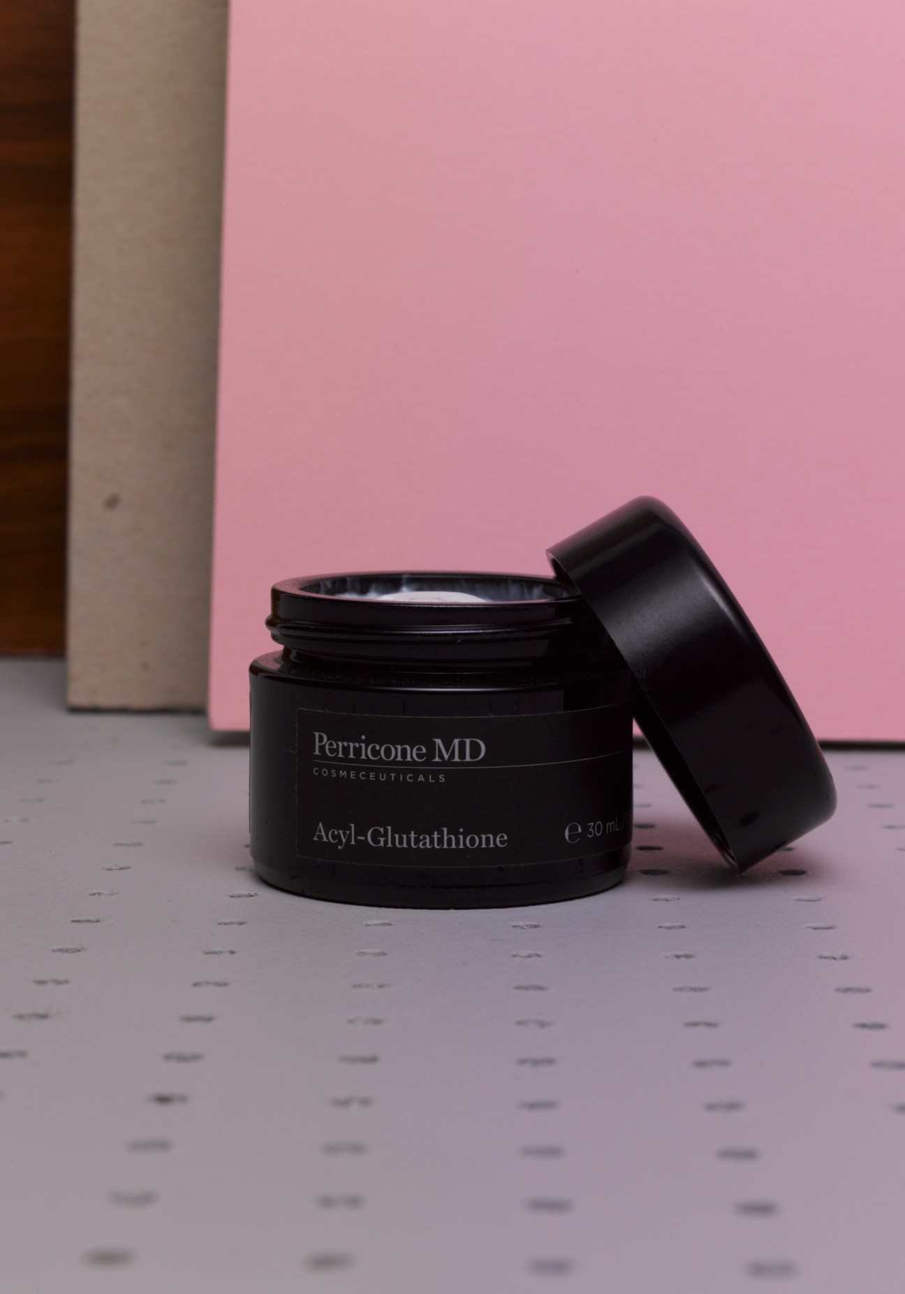 Perricone MD Acyl-Glutathione face cream in black jar with lid removed against pink background.