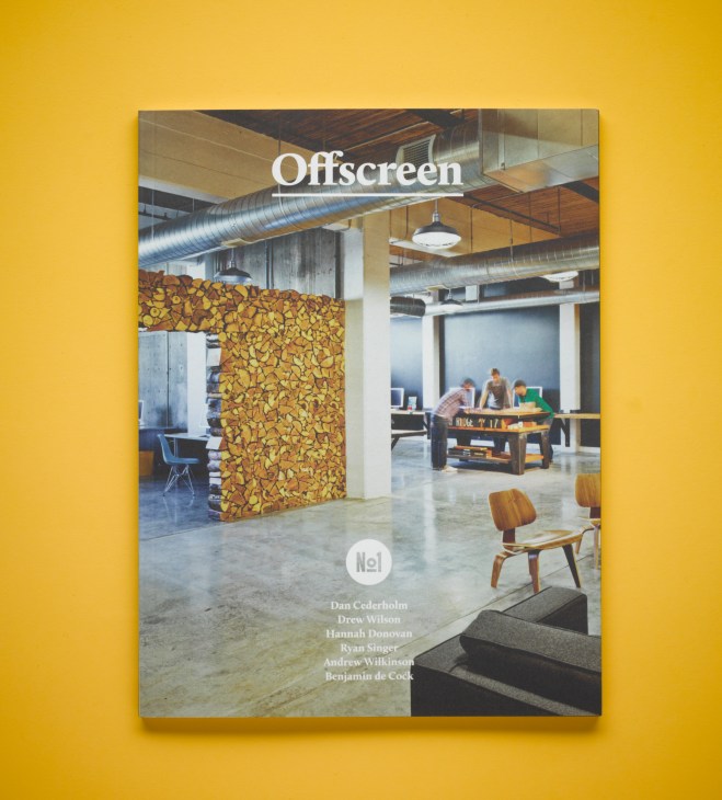 Offscreen magazine cover featuring an industrial workspace with wooden partition and people working at a foosball table against a yellow background.