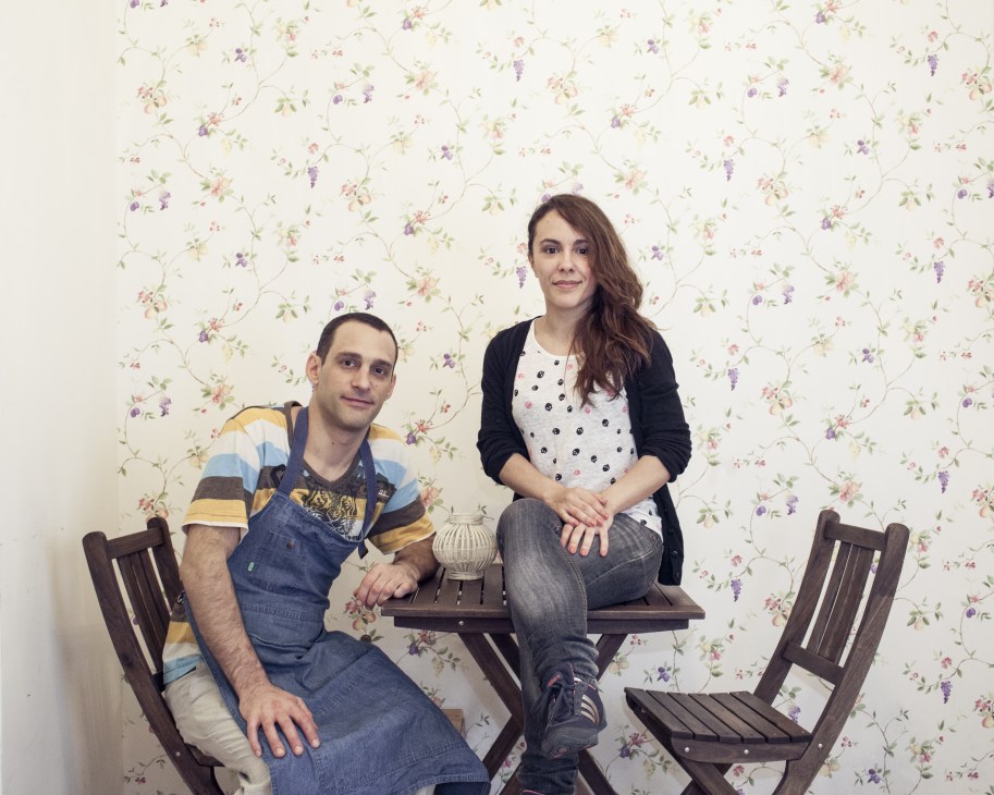 Daniel Golinelli and Silvana Cordobés, founders of Motha café, sitting together against floral wallpaper.