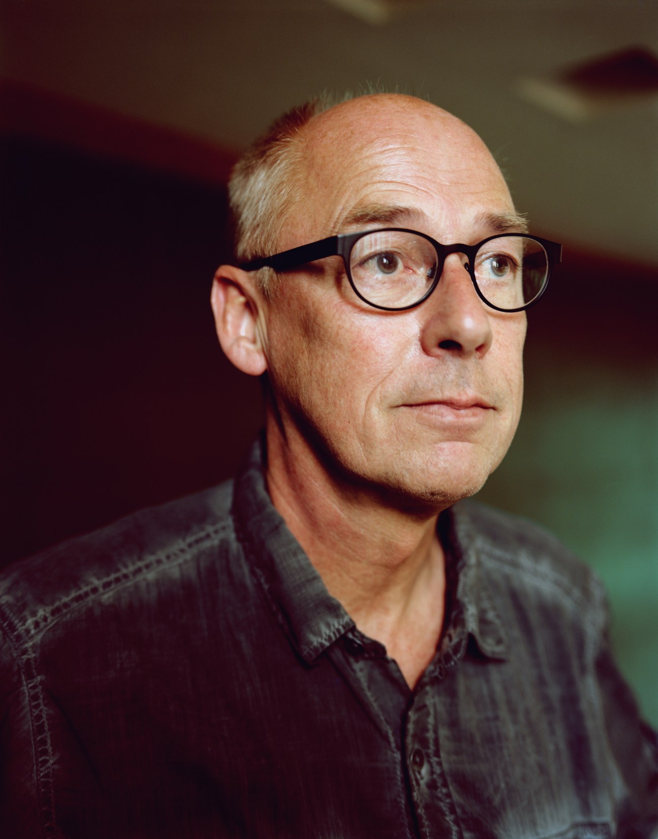 Portrait of Fons Gennisse, chief town planner for Hilversum, wearing glasses and a dark shirt.