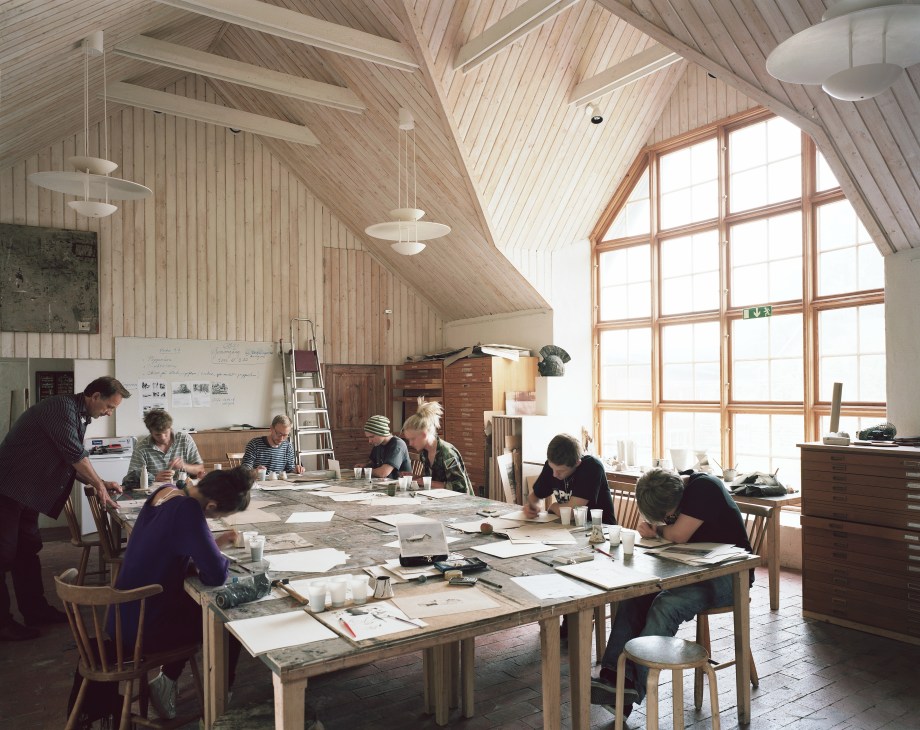 Students work at wooden tables in a bright, wood-paneled studio with vaulted ceilings at Capellagården.