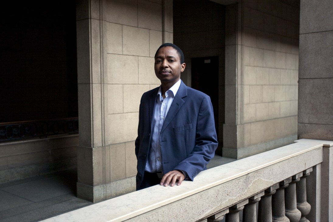 Joao Munguambe, Maputo's director of economic activities, stands in formal business attire outside a modern stone building.