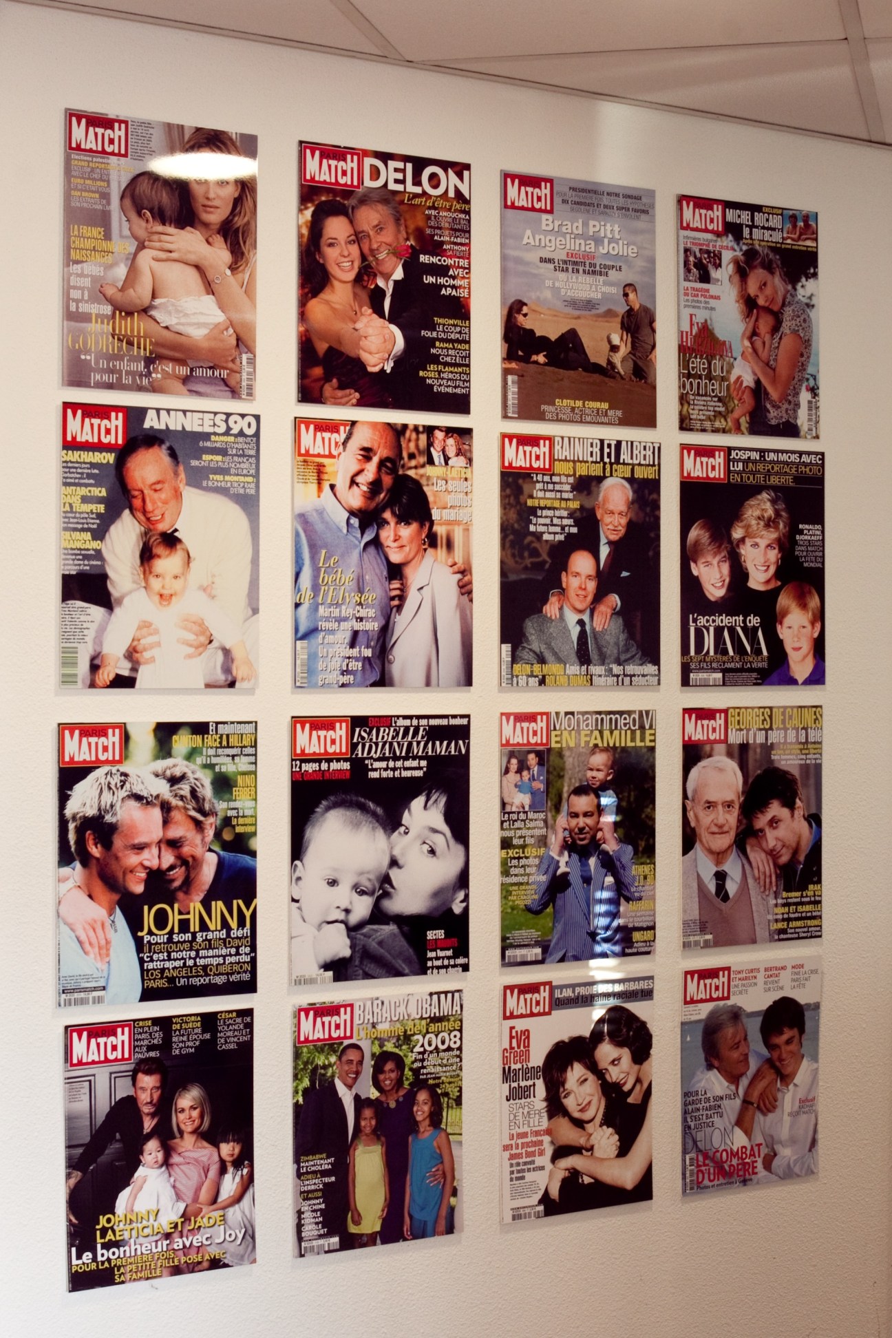 Multiple Paris Match magazine covers displayed on a white wall, featuring celebrity photographs and headlines.