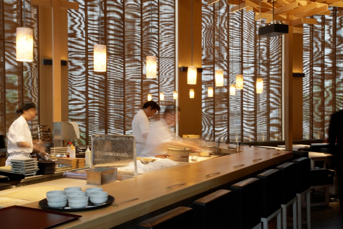Saké no Hana restaurant interior with sushi counter, chef, patterned screens and pendant lights.