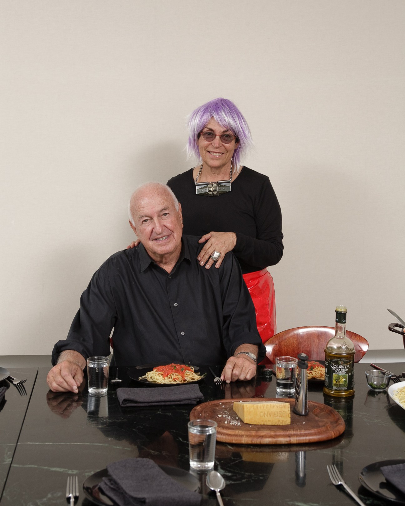 Don and Mera Rubell seated at a dining table with spaghetti and wine.