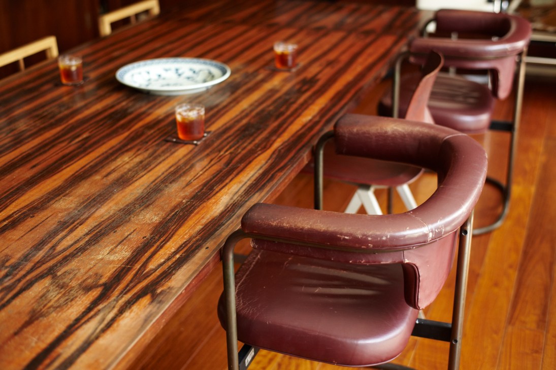 Wooden table with burgundy leather chairs and place settings in Simplicity Tokyo office