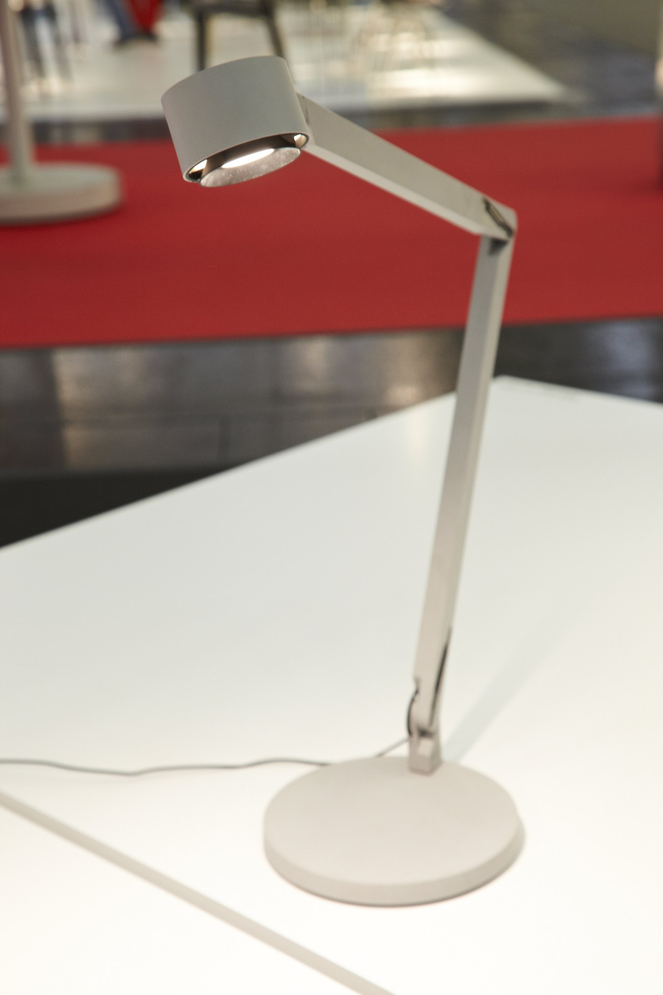 White articulated desk lamp by Wästberg with adjustable arm on round base.