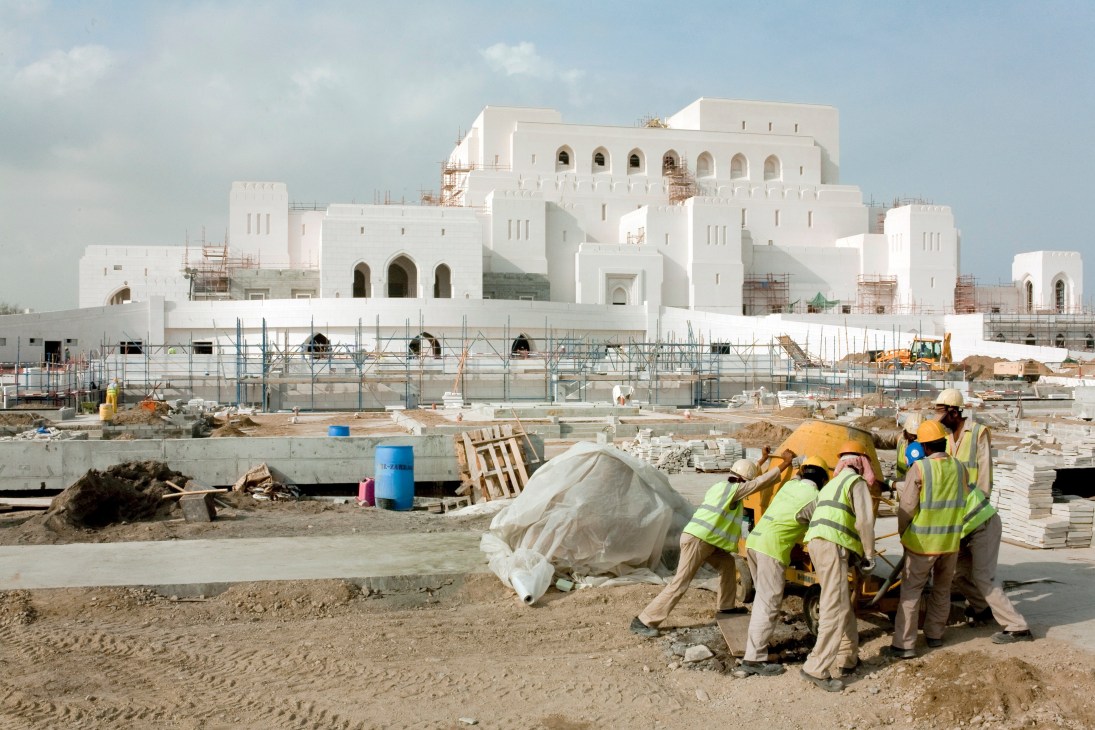 Construction workers in safety gear building the Royal Opera House in Muscat, Oman.