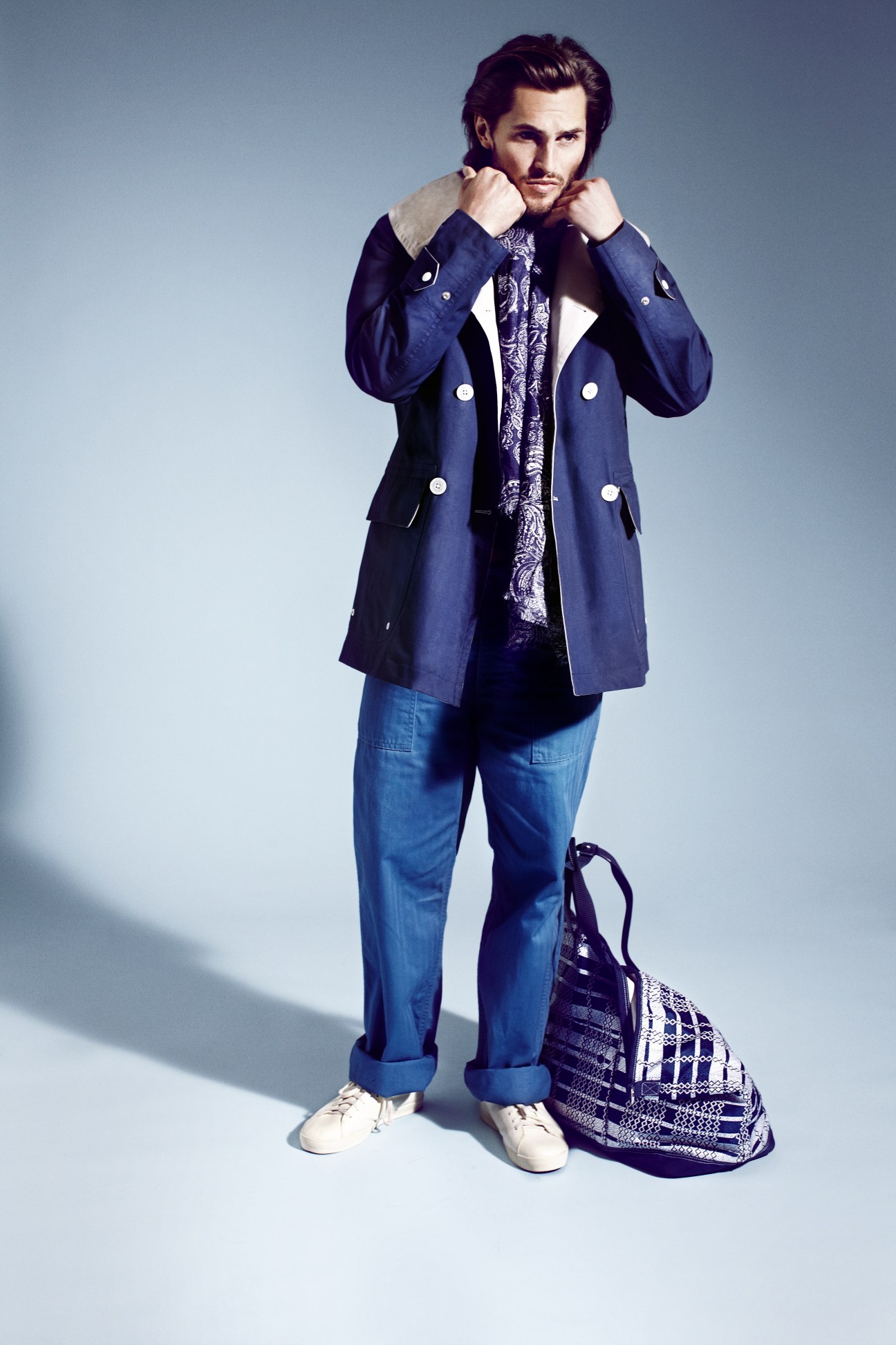 Man wearing navy Nanamica jacket, Boglioli shirt, and Engineered Garments trousers with White Mountaineering bag.