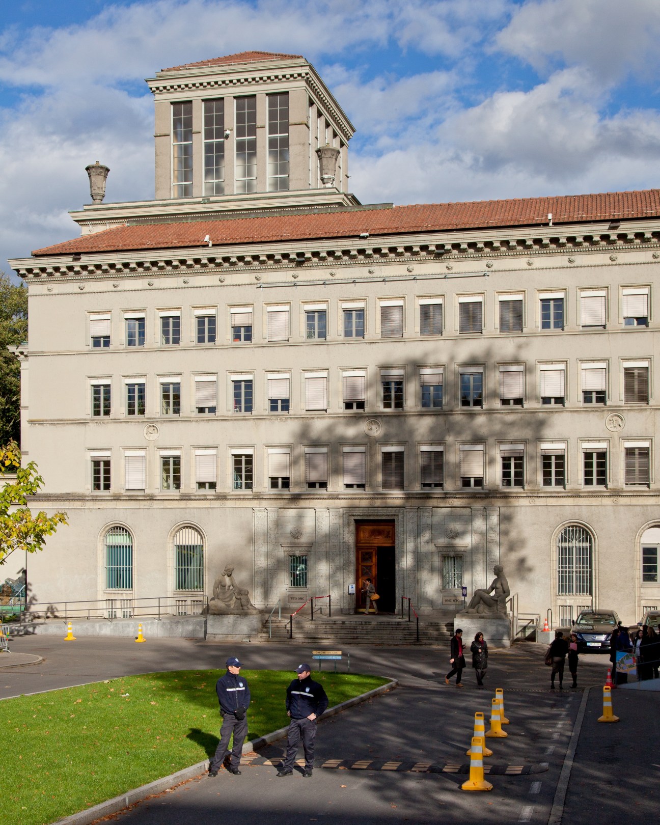 Neoclassical institutional building with ornate tower and columned entrance in Geneva.