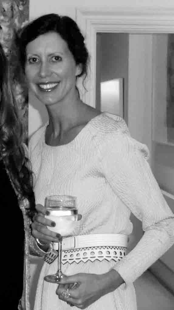 Black and white portrait of Valeria Napoleone holding a drink at an indoor event.