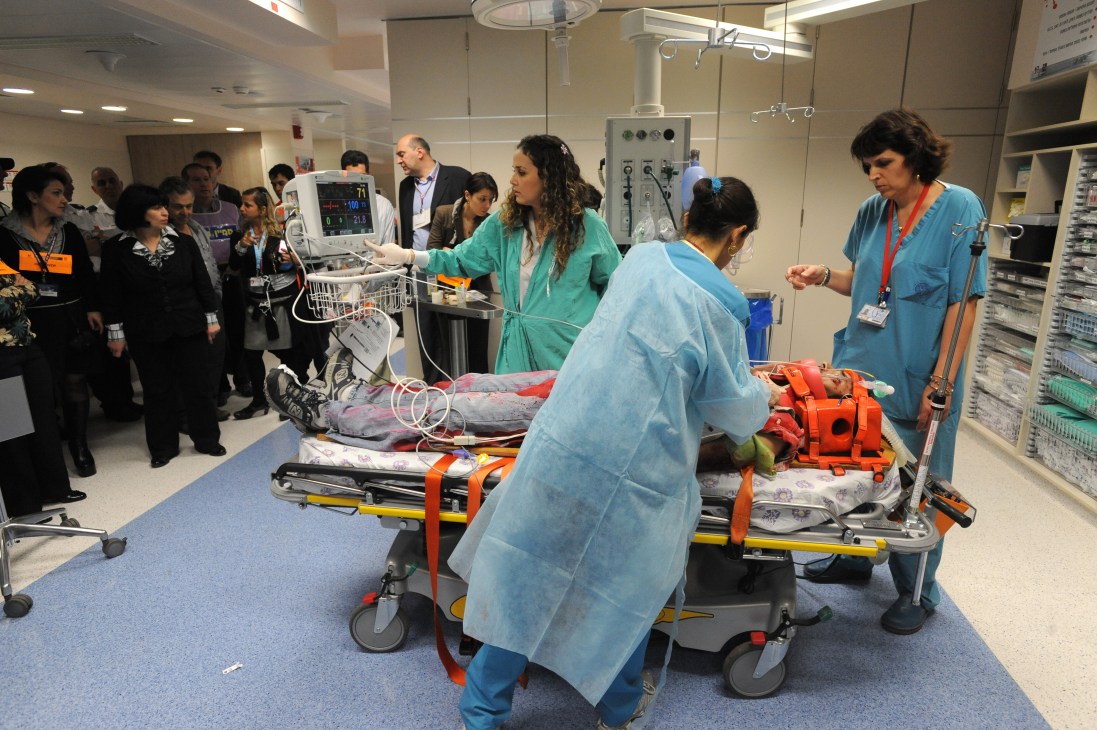 Medical staff demonstrate emergency treatment procedures to international trainees in a hospital setting.