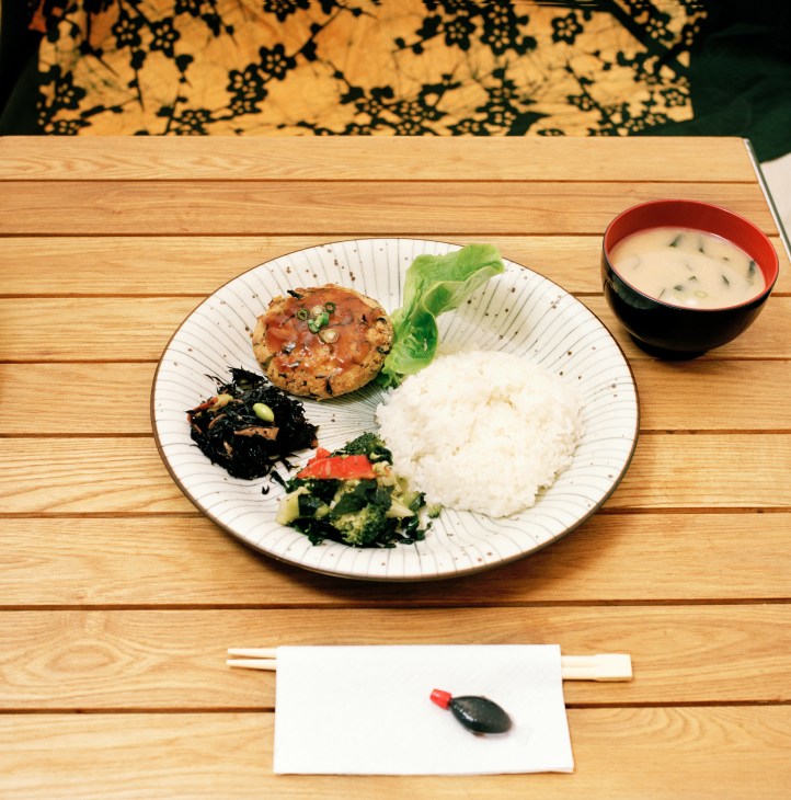 Japanese meal with rice, grilled meat patty, vegetables and miso soup on wooden table at Cha No Ma.