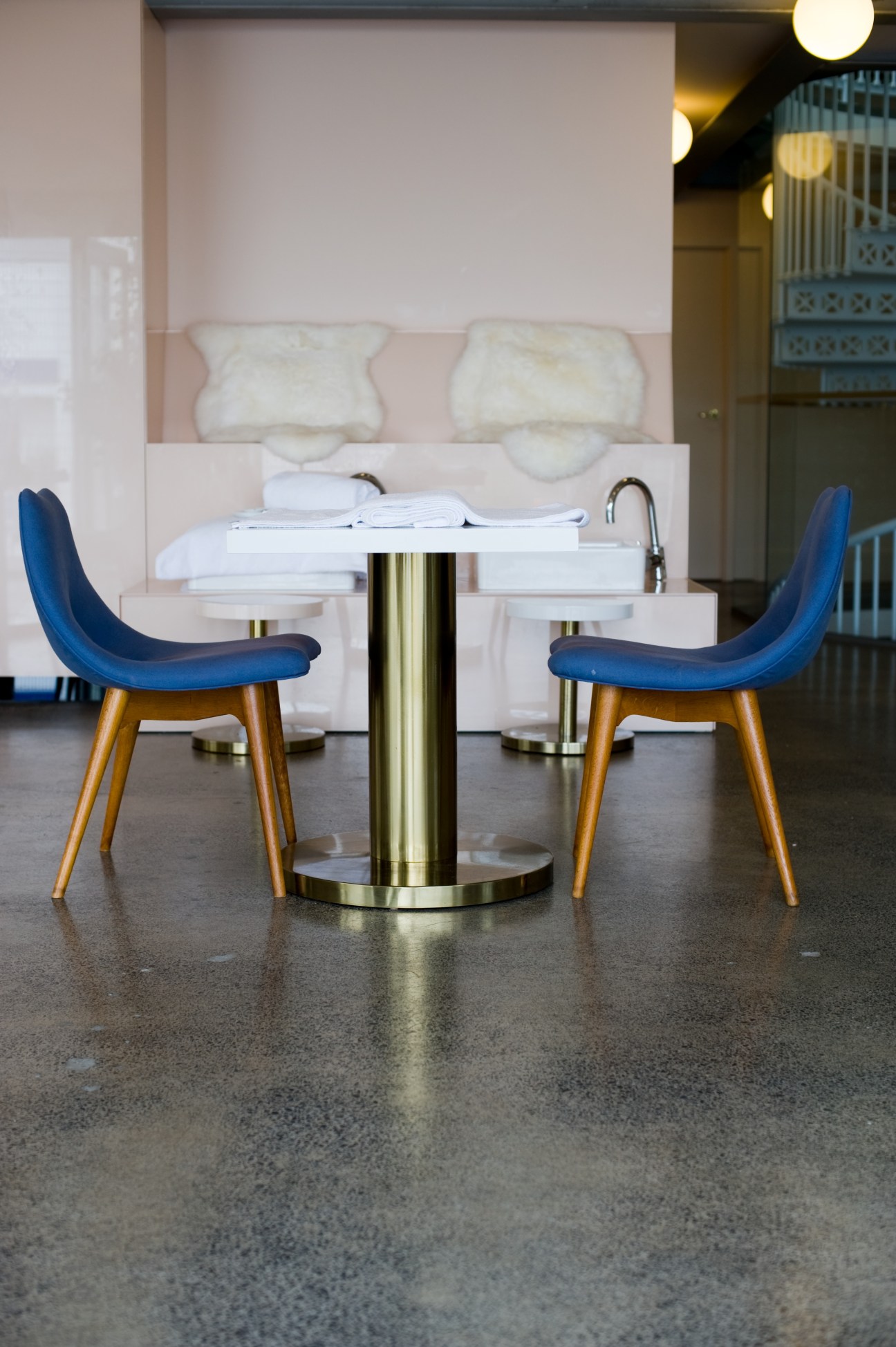 Interior of The Department Store in Auckland showing a modern seating area with blue chairs and a round brass table.