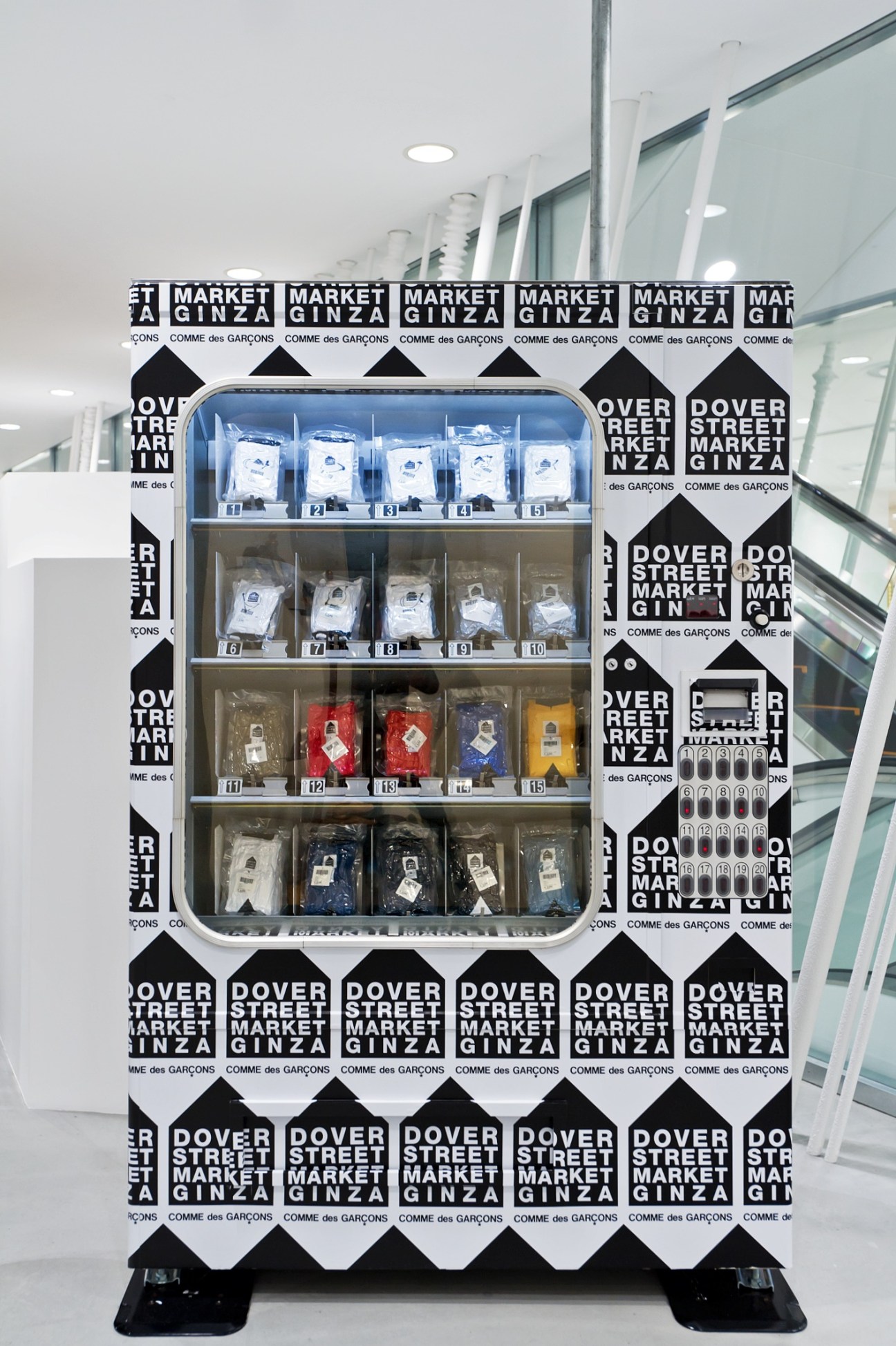 Dover Street Market Ginza T-shirt vending machine with dsm branded packaging in white display case