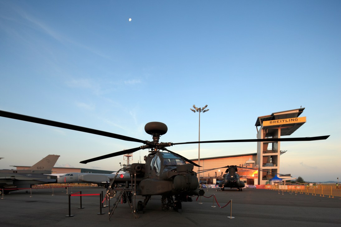 Boeing AH-64 Apache attack helicopter on display at Singapore Air Show with Breitling tower behind.