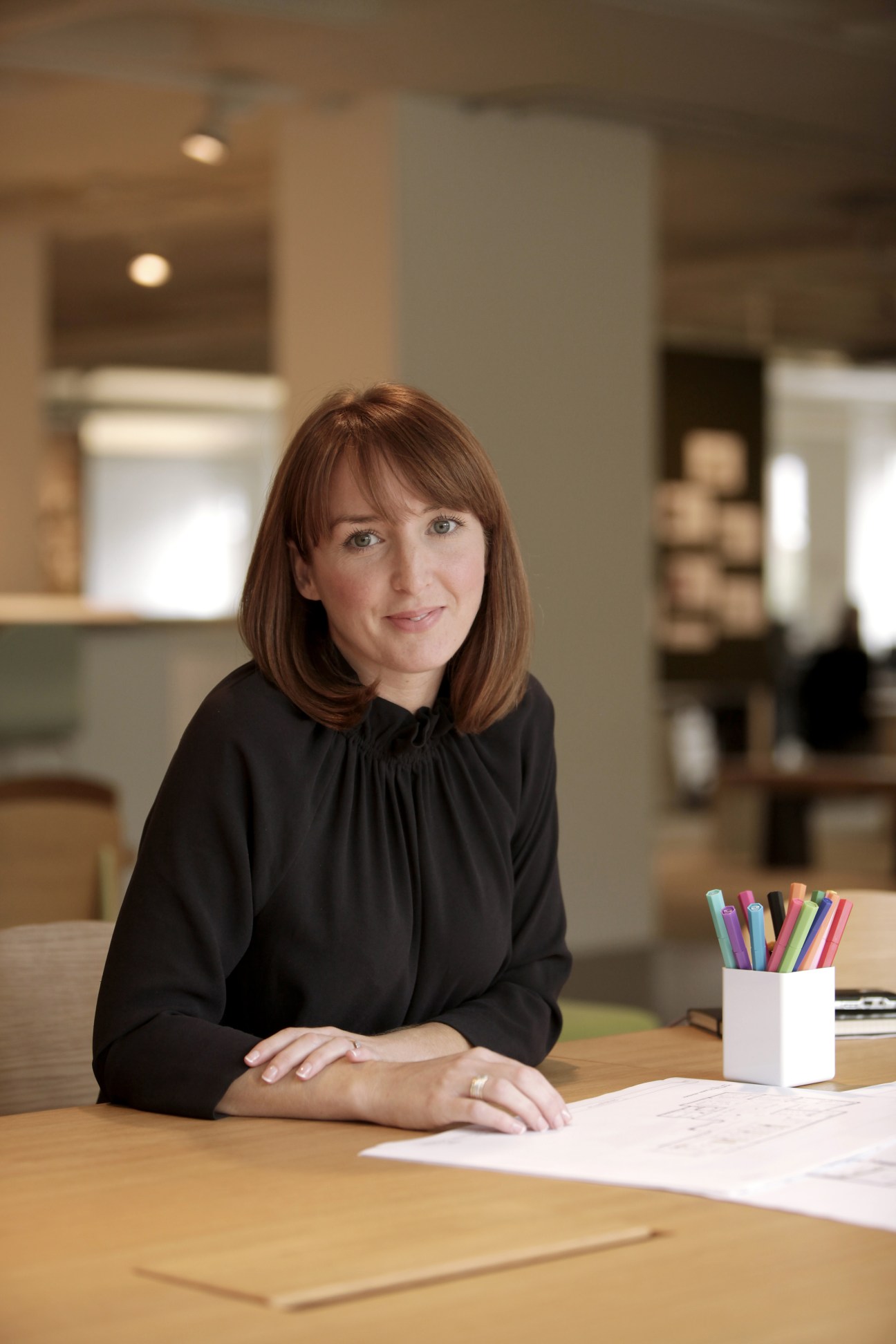 Fiona Kennedy, EF's creative director of architecture and built design, sits at a desk in a modern office space.