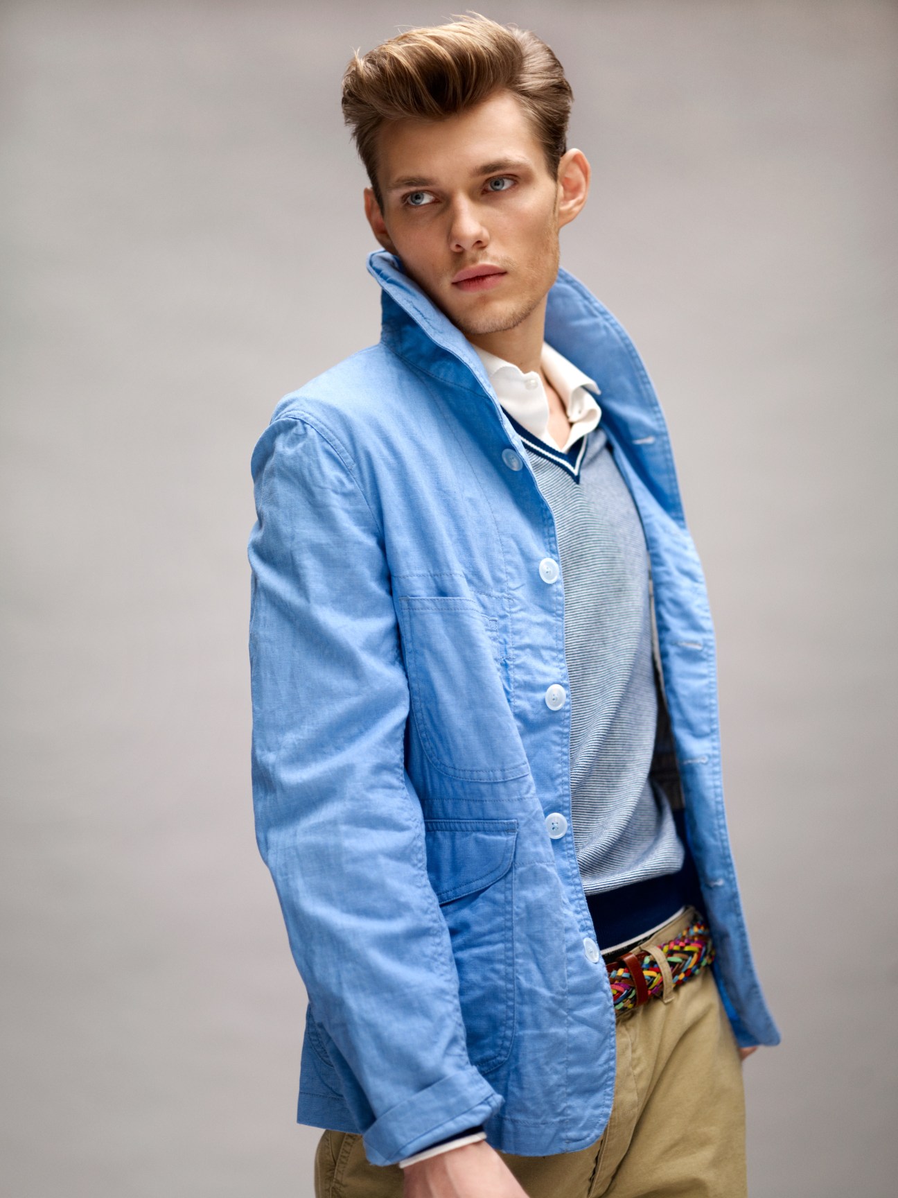 Male model wearing a light blue Woolrich Woolen Mills jacket over a Hackett polo collar jumper and Aspesi trousers.