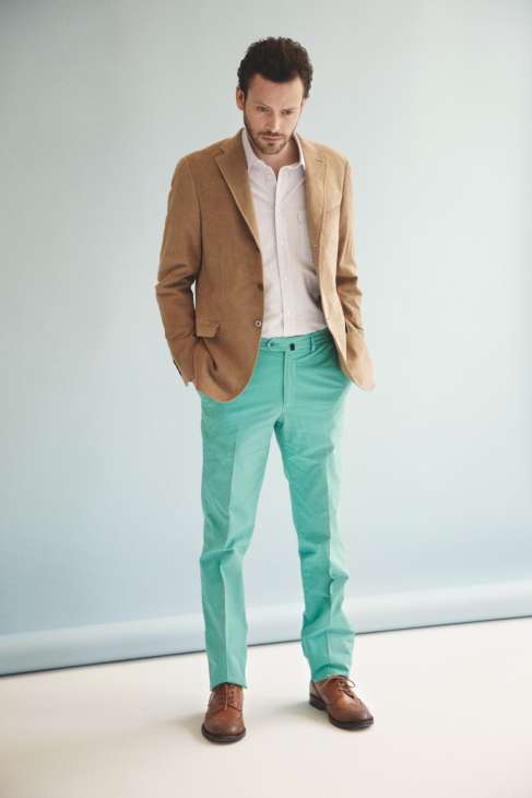 Man wearing a camel blazer, white shirt, mint green trousers and brown shoes.