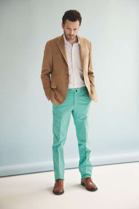 Man wearing a camel blazer, white shirt, mint green trousers and brown shoes.