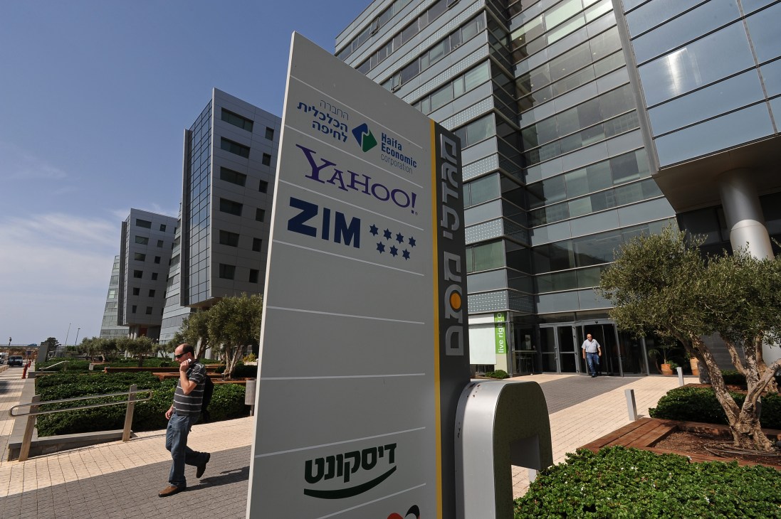 Haifa's southern hi-tech industry area with Yahoo and other tech company signs near modern office buildings.
