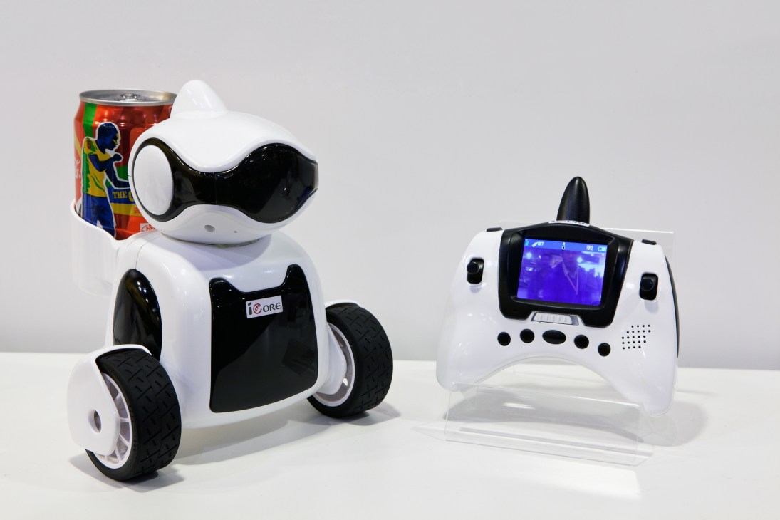 iCore robot from iSee Toys with white and black body next to wireless controller with display screen.