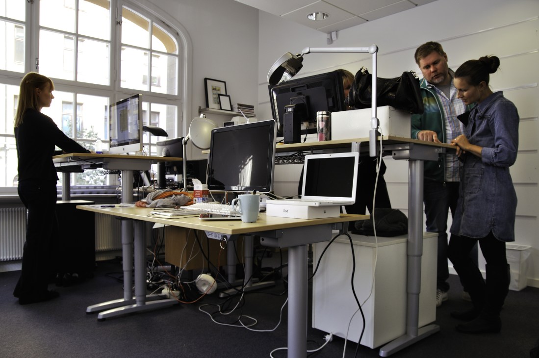Bonnier employees working in the Mag+ digital magazine office with computers and standing desks.