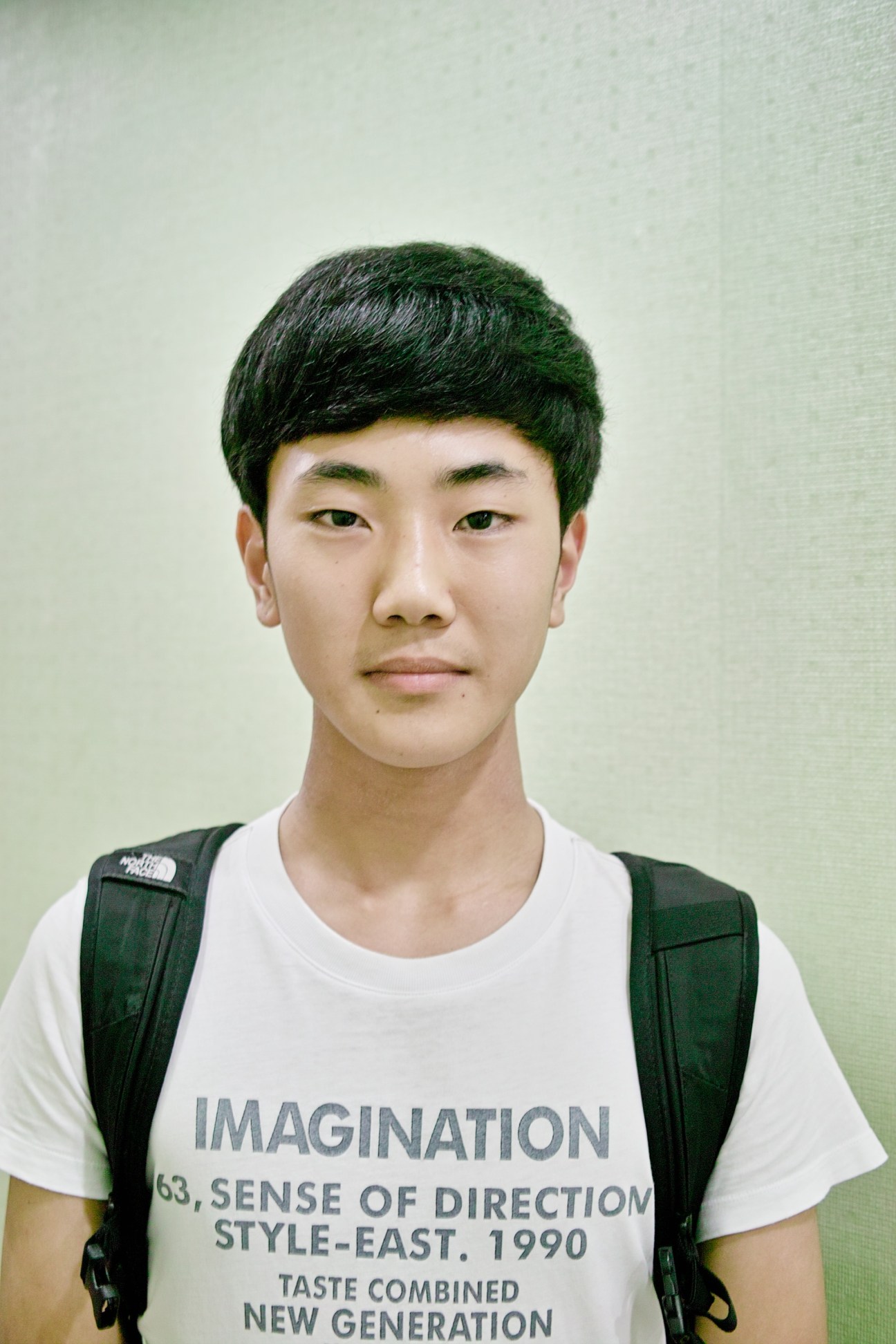 Portrait of Lee Dong-hyeong, a 16-year-old South Korean student wearing a backpack and graphic t-shirt.