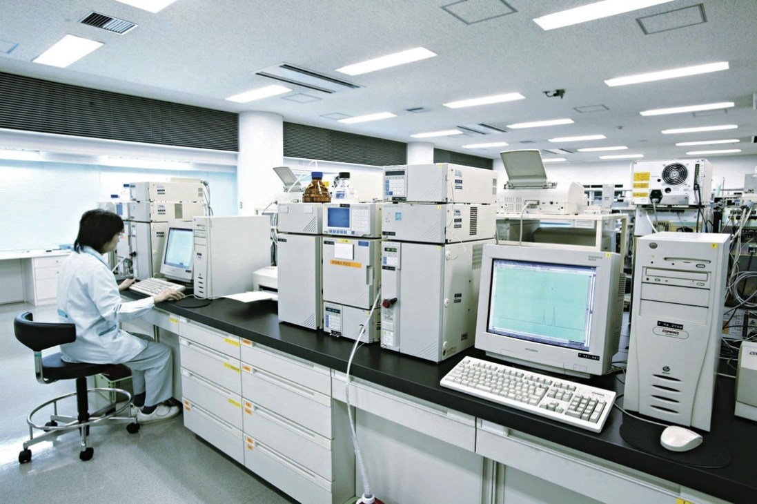 Laboratory technician conducting quality checks at Taisho Pharmaceutical Co using analytical equipment.