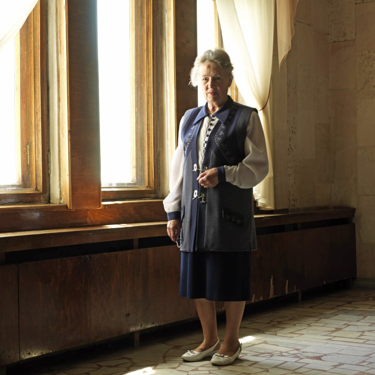 Ludmila, a curator at the Kaliningrad Museum of History & Arts, stands in a sunlit hallway with tall wooden-framed windows.