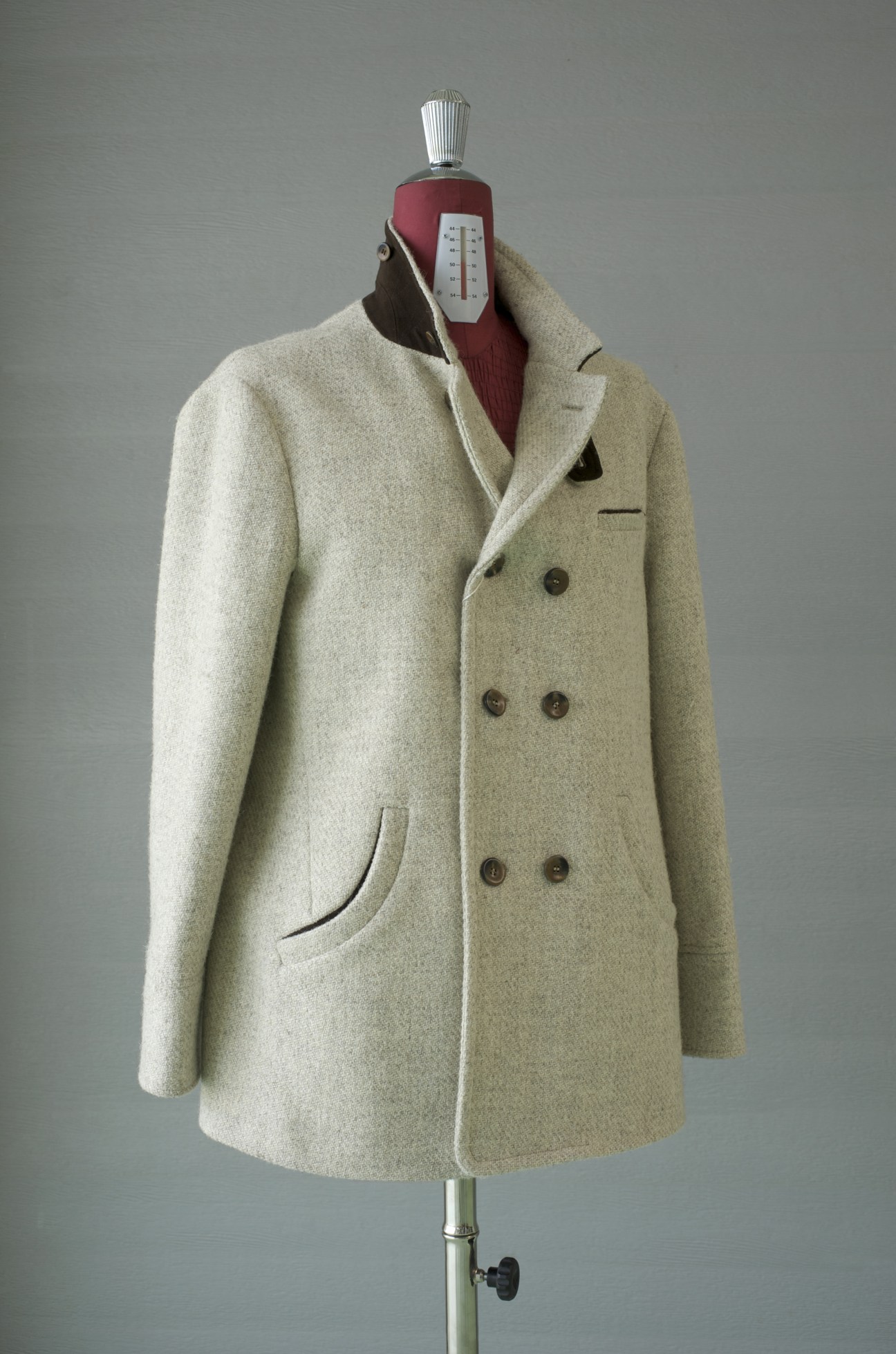 Cream-colored wool Lodra' jacket on tailoring dummy with double-breasted buttons and rounded pockets.