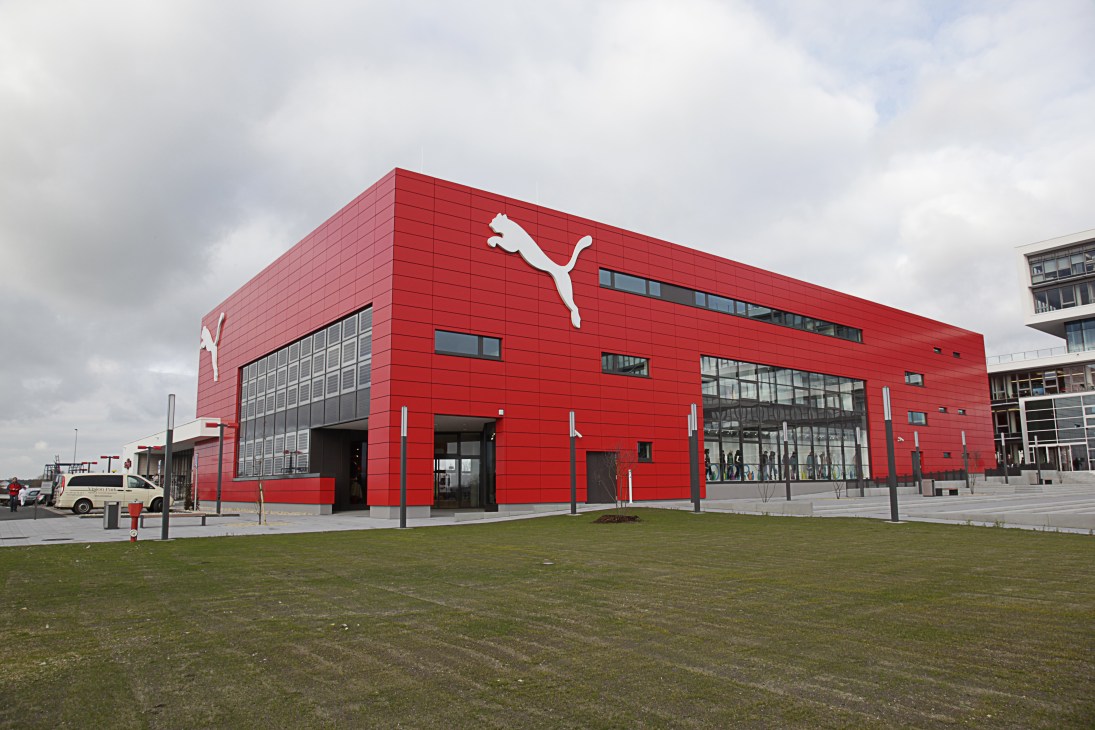 Red Puma outlet store building with large white puma logo in Herzogenaurach, Germany.