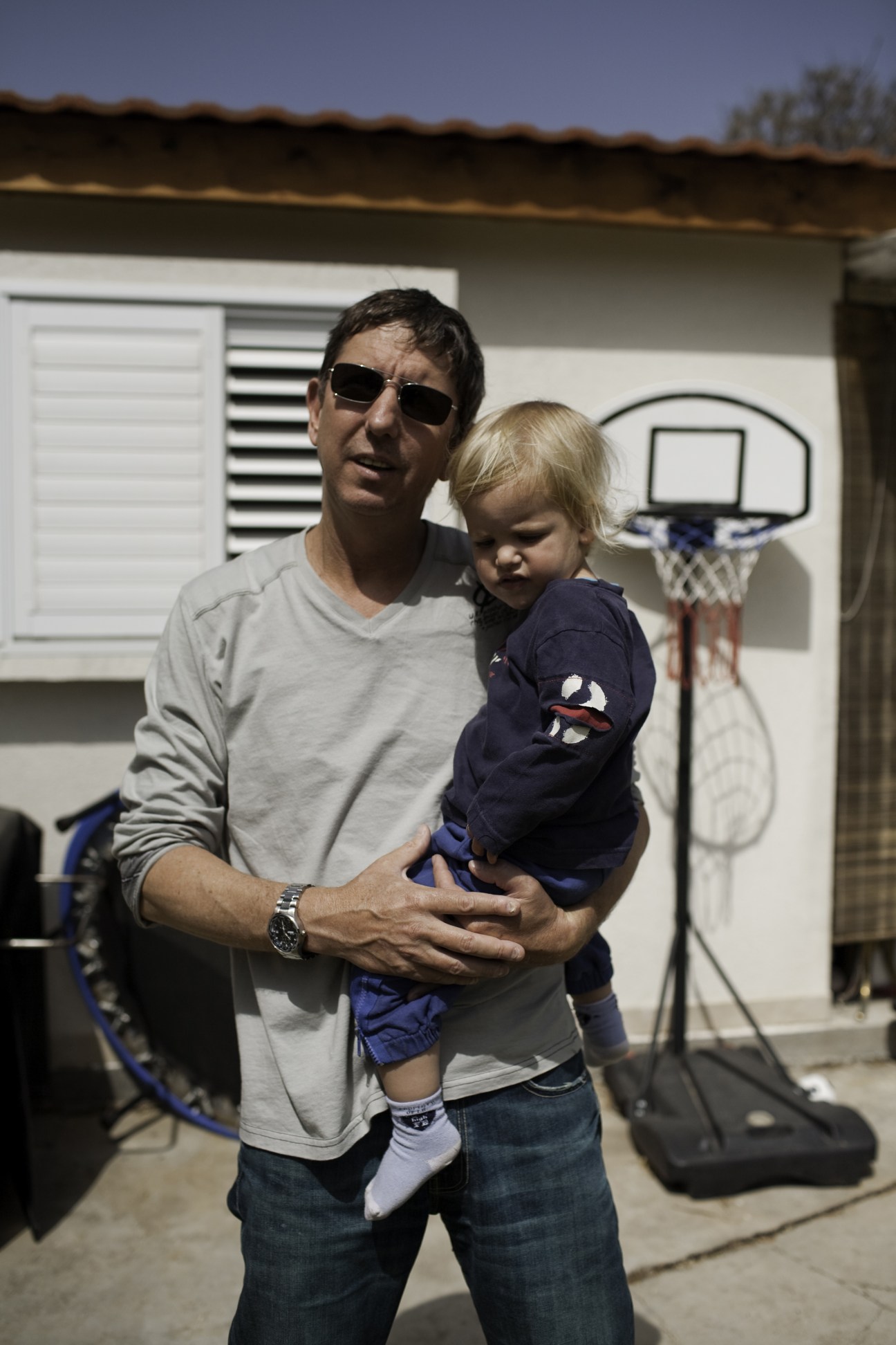 Boaz Alon holds his young son outside their house in Mishmar Hasharon kibbutz.