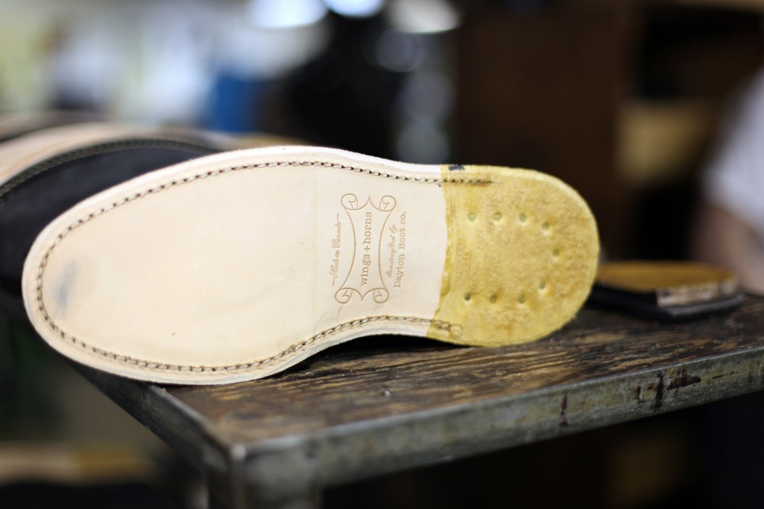 Boot sole showing cream leather insole with embossed Viberg logo and perforated yellow rubber heel
