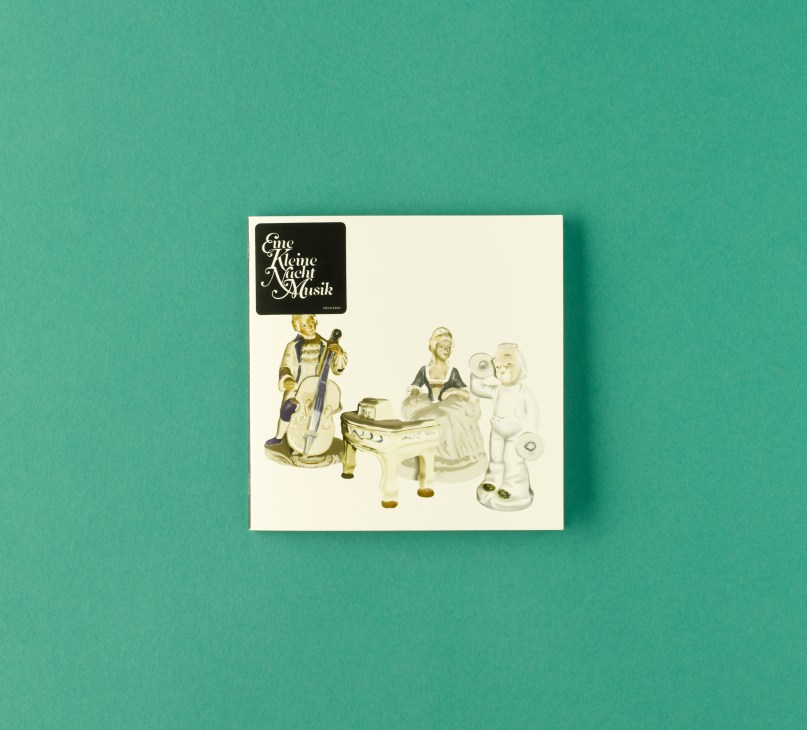 Eine Kleine Nacht Musik album cover featuring illustrated classical musicians on a turquoise background.