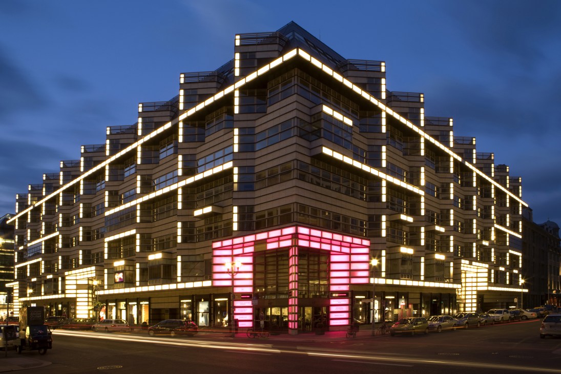 Illuminated modern building at night with luxury store entrance on Berlin's Friedrichstrasse where Meoclinic is located above.