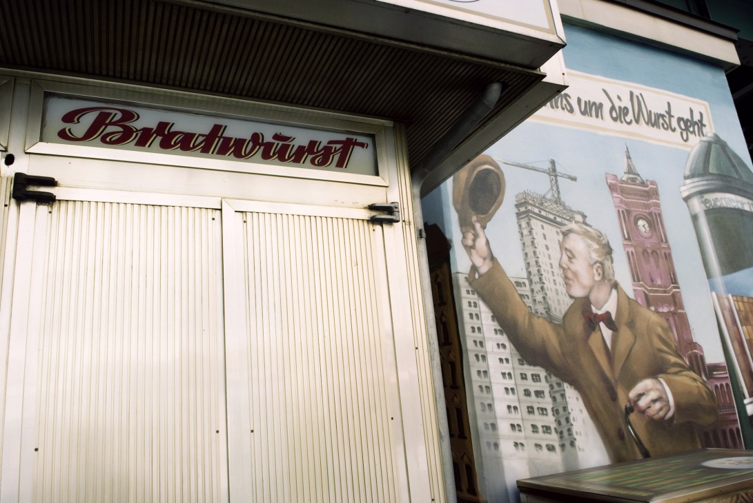 Konnopke's storefront signage and 1930s-style mural decoration under railway arches.